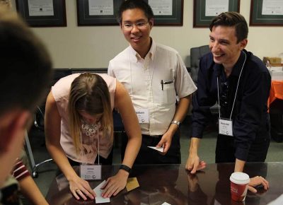 Emma Adams, William Xie, and Alexander Shirshov help their teams solve their team puzzle.