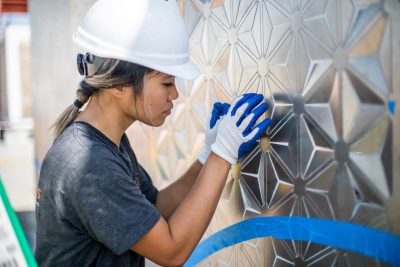 Michelle Le, a recently-graduated architecture student from Herndon, Virginia, presses in the screen wall's intricate pattern.