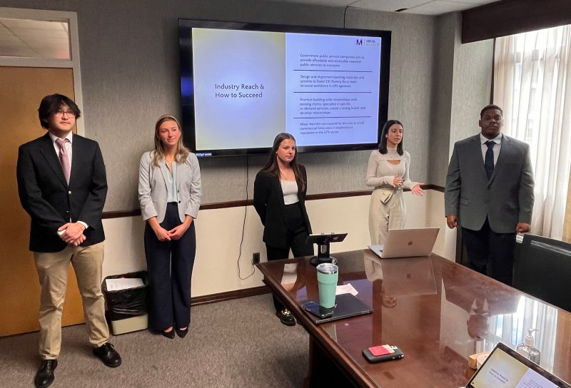 A team of students in the Management Consulting capstone course deliver their consultation presentation to the DEI-focused consulting firm, Mikal-Hamlett. Photo courtesy of Dirk Buengel.