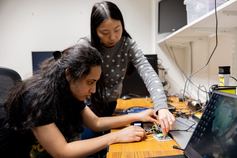 Professor works with a student on a piece of hardware