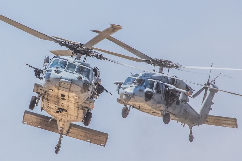 Two MH-60S Knighthawk aircraft fly.